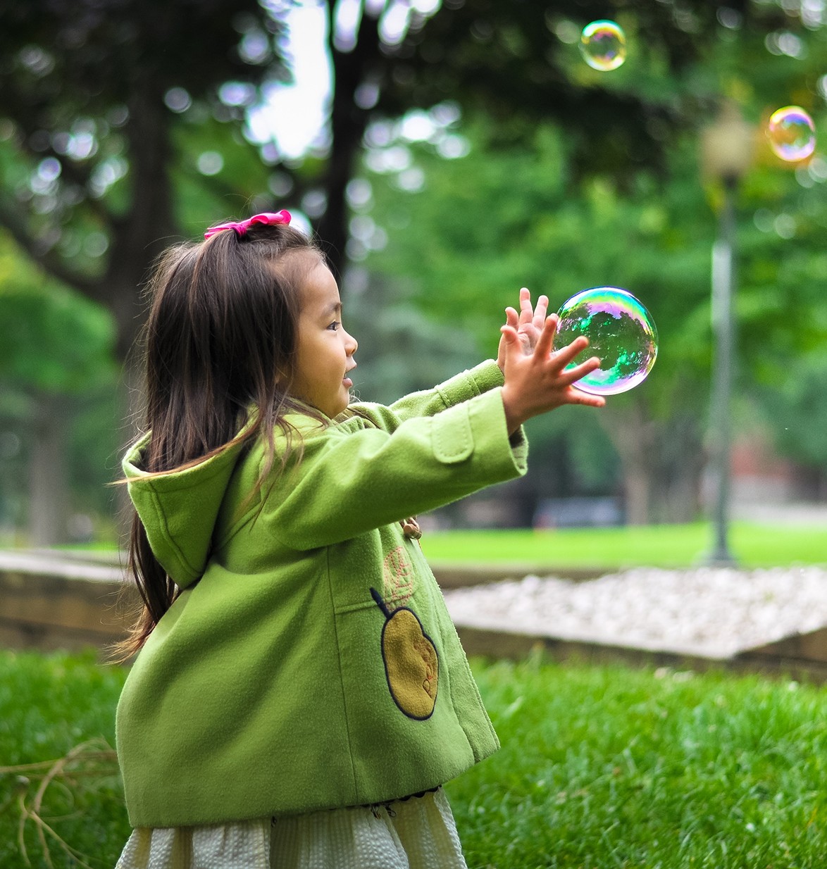 Enfant tendant la main vers une bulle de savon
